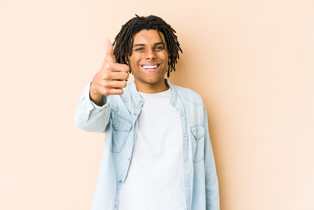 Jonge Afro-Amerikaanse rastamens die en duim glimlacht opheft
