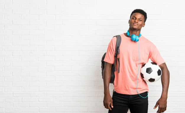 Jonge afro Amerikaanse studenten die een voetbalbal houden