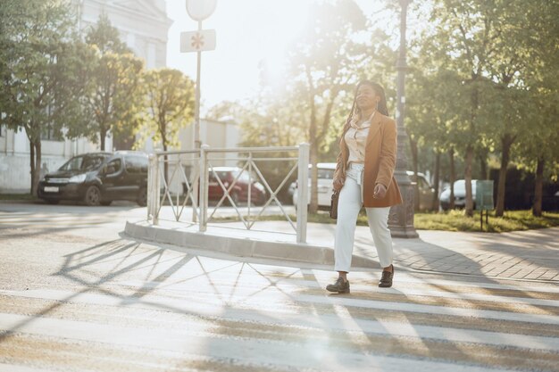 Jonge Afro-Amerikaanse vrouw die de straat oversteekt