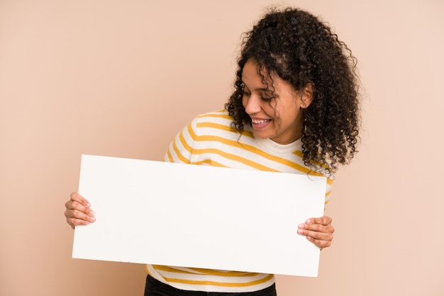 Jonge afro-amerikaanse vrouw die een banner geïsoleerd houdt