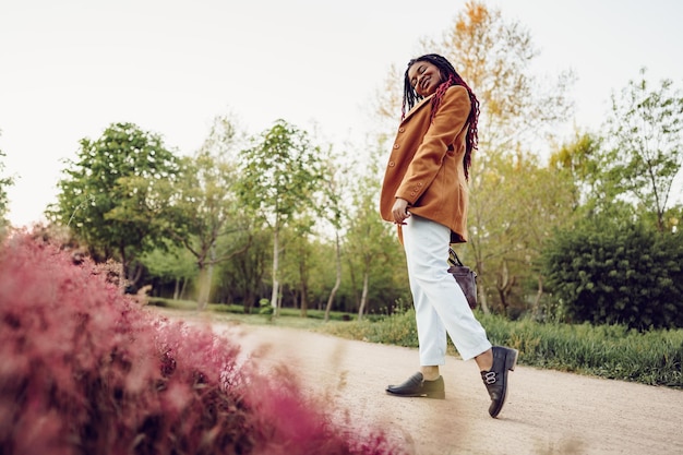 Jonge afro-amerikaanse vrouw die een wandeling maakt in een park