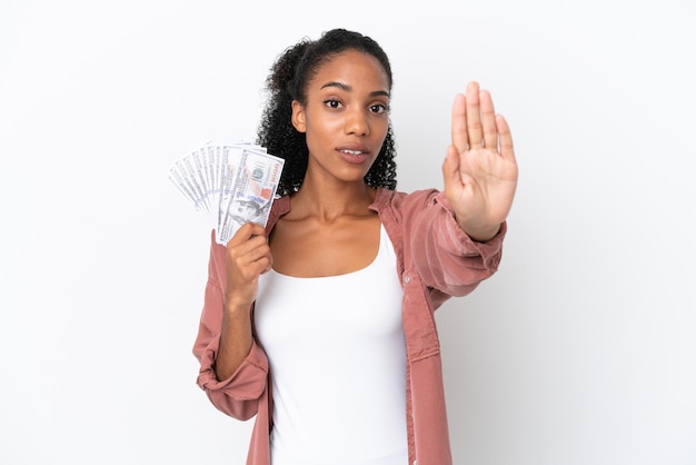 Jonge Afro-Amerikaanse vrouw die veel geld neemt geïsoleerd op een witte achtergrond die een stopgebaar maakt