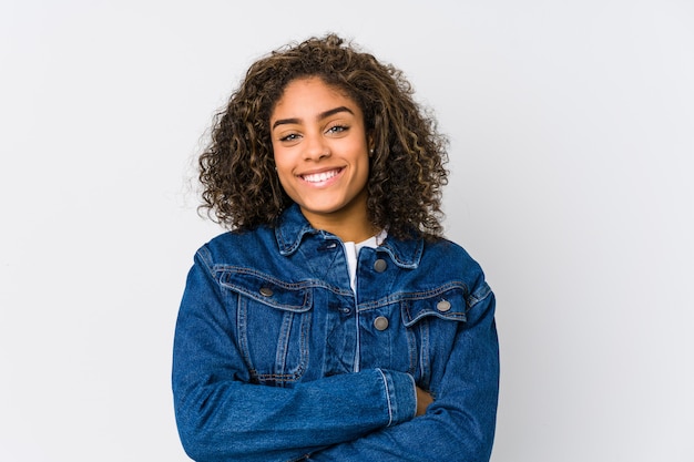 Jonge Afro-Amerikaanse vrouw die zich zeker voelt, armen met vastberadenheid kruist.