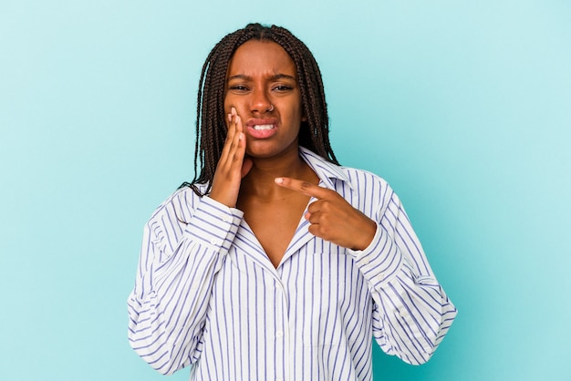 Jonge Afro-Amerikaanse vrouw geïsoleerd op blauwe achtergrond met een sterke tanden pijn, kiespijn.