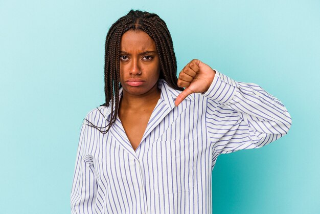 Jonge afro-amerikaanse vrouw geïsoleerd op een blauwe achtergrond met duim naar beneden en het uiten van afkeer.