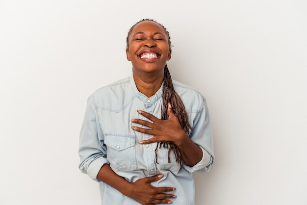 Jonge Afro-Amerikaanse vrouw geïsoleerd op een witte achtergrond lacht vrolijk en heeft plezier met het houden van handen op de maag.