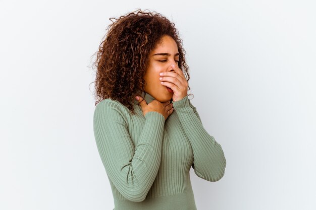 Jonge afro-amerikaanse vrouw geïsoleerd op een witte achtergrond lijdt pijn in de keel als gevolg van een virus of infectie.