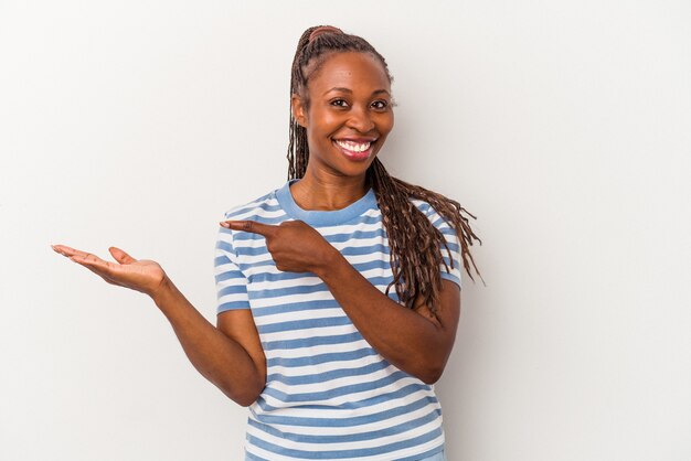 Jonge Afro-Amerikaanse vrouw geïsoleerd op een witte achtergrond opgewonden met een kopie ruimte op de palm.