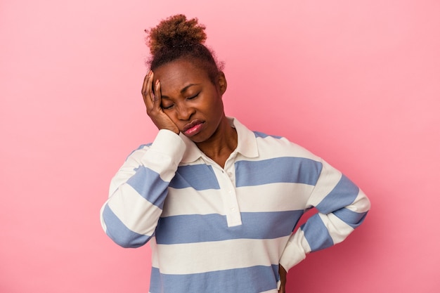 Jonge afro-amerikaanse vrouw geïsoleerd op roze achtergrond die zich verveelt, vermoeid is en een ontspannen dag nodig heeft.