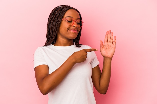 Jonge Afro-Amerikaanse vrouw geïsoleerd op roze achtergrond glimlachend vrolijk weergegeven: nummer vijf met vingers.