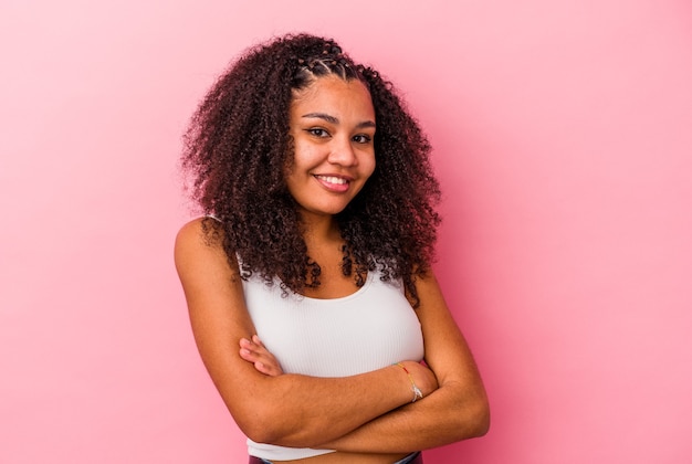 Jonge Afro-Amerikaanse vrouw geïsoleerd op roze achtergrond lachen en plezier maken.