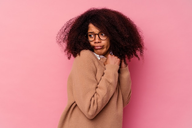 Jonge Afro-Amerikaanse vrouw geïsoleerd op roze bang en bang.