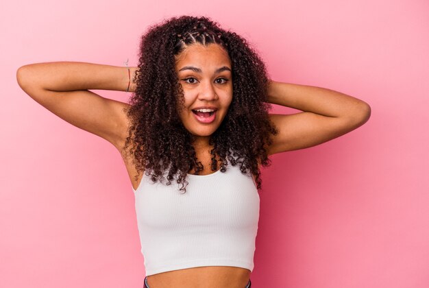 Jonge Afro-Amerikaanse vrouw geïsoleerd op roze muur schreeuwen, erg opgewonden, hartstochtelijk, tevreden met iets.