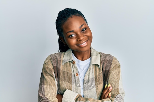 Jonge Afro-Amerikaanse vrouw, gekleed in vrijetijdskleding, blij gezicht lachend met gekruiste armen kijkend naar de positieve persoon van de camera