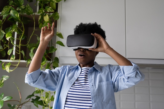 Jonge Afro-Amerikaanse vrouw met 3D VR-bril op ogen staat in de kamer en geniet van virtual reality