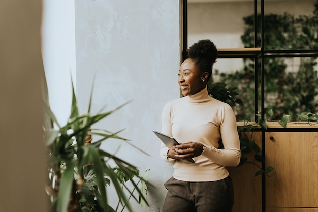 Jonge Afro-Amerikaanse vrouw met een digitale tablet in het kantoor