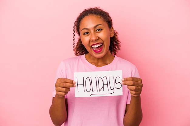 Jonge Afro-Amerikaanse vrouw met een vakantie plakkaat geïsoleerd op roze background