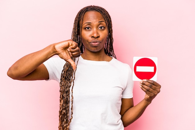 Jonge Afro-Amerikaanse vrouw met een verboden bord geïsoleerd op roze background