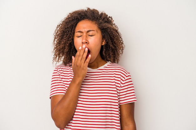 Jonge Afro-Amerikaanse vrouw met krullend haar geïsoleerd op een witte achtergrond geeuwen met een vermoeid gebaar voor mond met de hand.