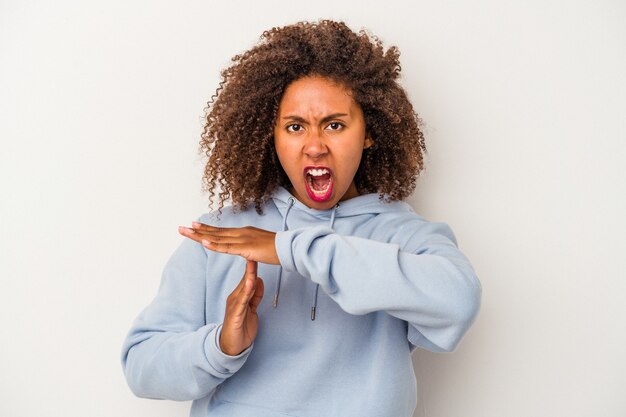 Jonge Afro-Amerikaanse vrouw met krullend haar geïsoleerd op een witte achtergrond met een time-out gebaar.