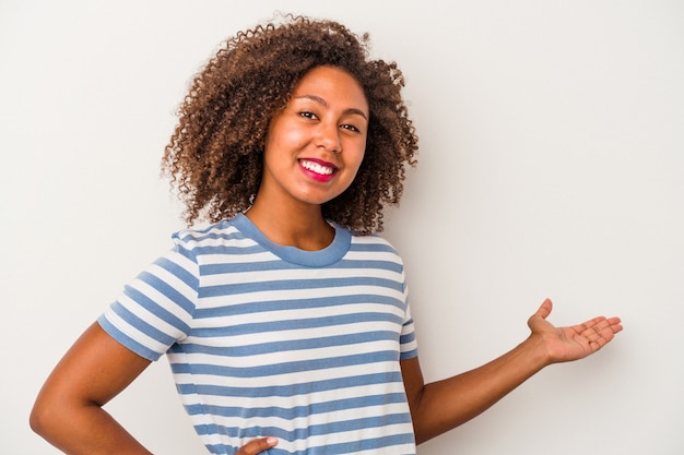 Jonge Afro-Amerikaanse vrouw met krullend haar geïsoleerd op een witte achtergrond met een welkome uitdrukking.