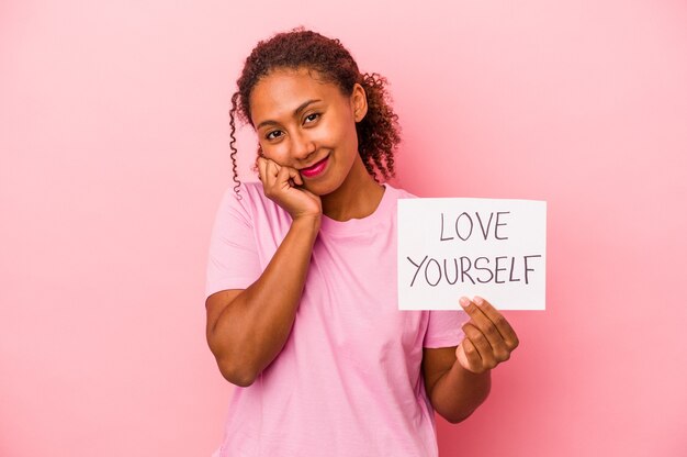 Jonge Afro-Amerikaanse vrouw met liefde jezelf plakkaat geïsoleerd op roze achtergrond