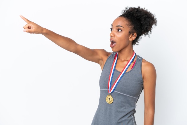 Jonge Afro-Amerikaanse vrouw met medailles geïsoleerd op een witte achtergrond die weg wijst