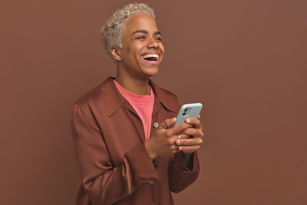Jonge afro-amerikaanse vrouw met telefoonlach na het bekijken van een stand-upshow