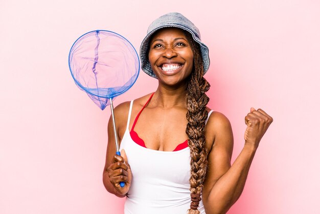 Jonge Afro-Amerikaanse vrouw met visnet geïsoleerd op roze background