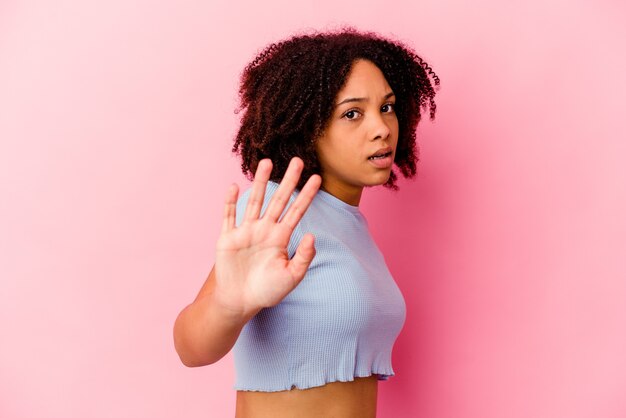 Jonge afro-amerikaanse vrouw van gemengd ras geïsoleerd geschokt als gevolg van een dreigend gevaar