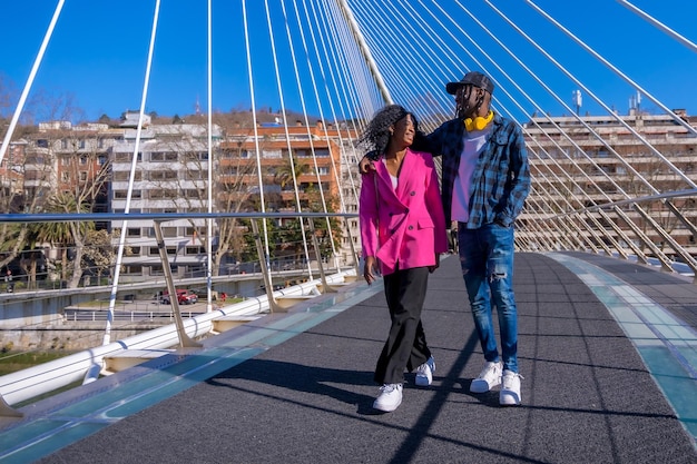 Jonge afro-amerikaanse vrouwen in de vrienden van het stadslevensconcept omhelsden plezier op een brug