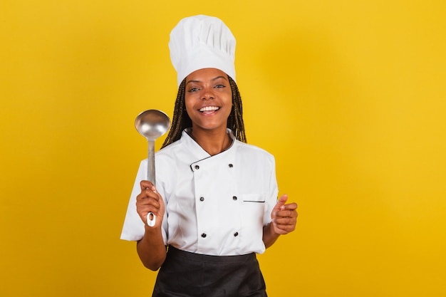 Jonge afro Braziliaanse vrouw chef kok met koken pollepel keuken accessoire