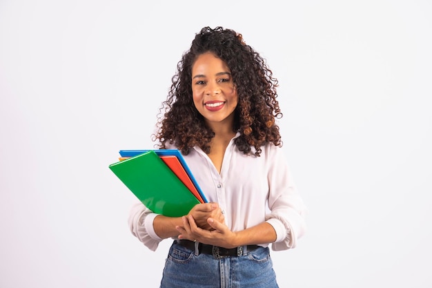 Jonge afro student vrouw met notebooks op witte achtergrond Middelbare school hogeschool en universiteit student concept