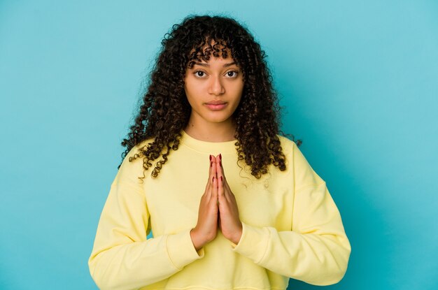 Jonge afro vrouw geïsoleerd bidden, toewijding, religieuze persoon op zoek naar goddelijke inspiratie