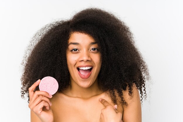 Jonge afro vrouw met een gezichtsschijf verrast verrast wijzend op zichzelf, breed glimlachend
