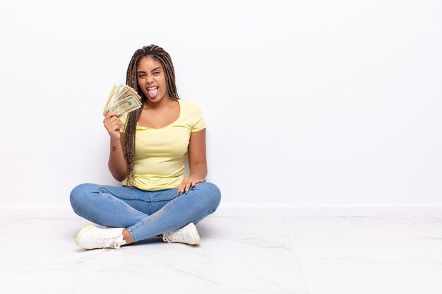 Jonge afro-vrouw met een vrolijke, zorgeloze, rebelse houding