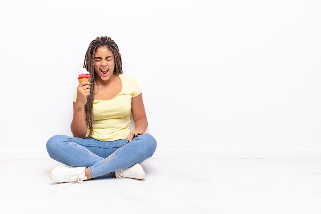 Jonge afrovrouw die agressief schreeuwt, zeer boos kijkt