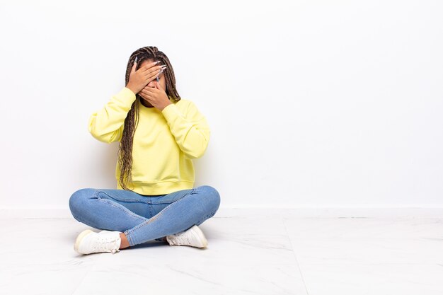 Jonge afrovrouw die gezicht behandelt met beide handen die nee zeggen tegen de camera! afbeeldingen weigeren