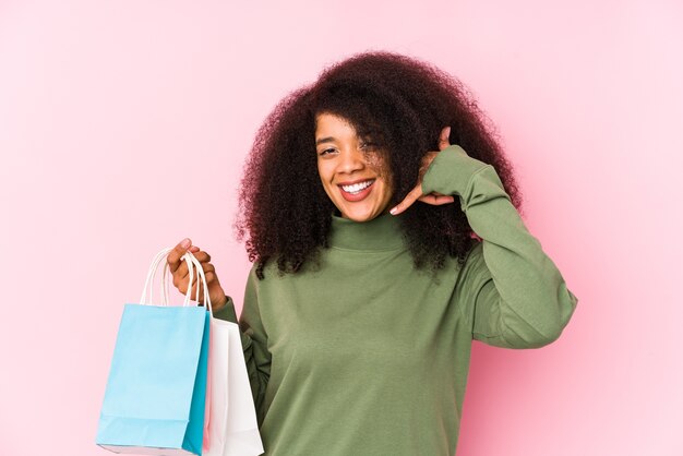 Jonge afrovrouw die op roze winkelt