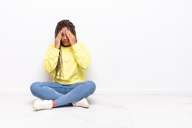 Jonge afrovrouw kijkt gestrest en gefrustreerd, werkt onder druk met hoofdpijn en heeft problemen