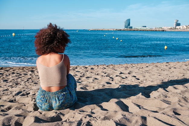 Jonge afrovrouw op het strand van Barcelona vroeg in de ochtend