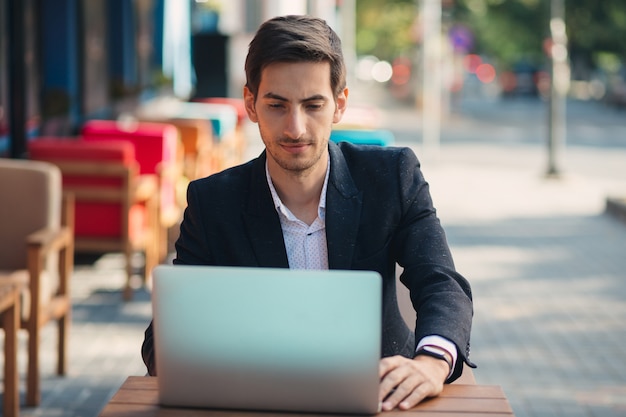 Jonge ambitieuze ondernemer die op de laptop werkt