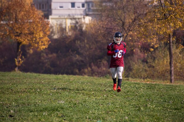 jonge american football-speler in actie tijdens de training op het veld