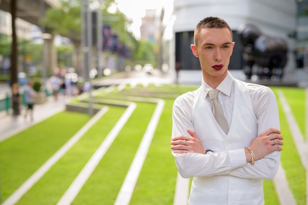 Jonge androgyne zakenman die lippenstift draagt