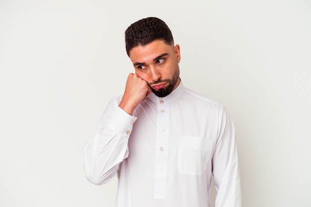 Jonge arabische man met typische arabische kleding geïsoleerd op een witte achtergrond die zich verdrietig en peinzend voelt, kijkend naar kopieerruimte.