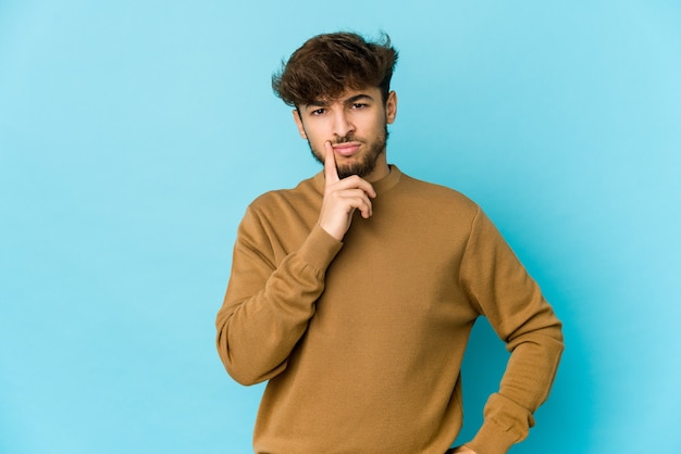 Jonge Arabische man op blauw overweegt, een strategie plannen, nadenken over de manier van een bedrijf.