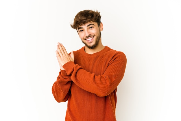 Jonge Arabische man op wit energiek en comfortabel gevoel, zelfverzekerd handen wrijven.