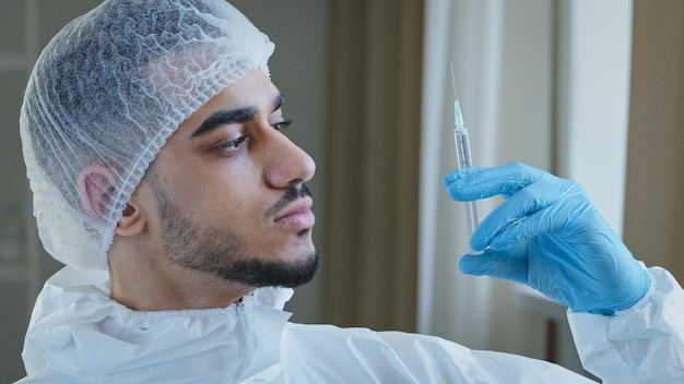 Jonge arabische mannelijke spaanse arts beoefenaar chirurg in speciale medische beschermende uniforme handschoenen