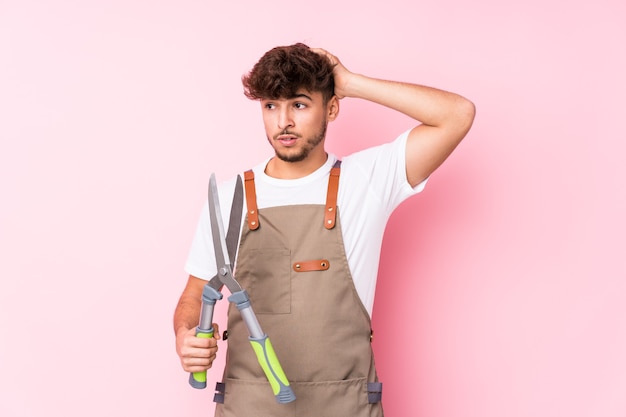 Jonge Arabische tuinman man geïsoleerd geschokt, hij herinnert zich een belangrijke ontmoeting.