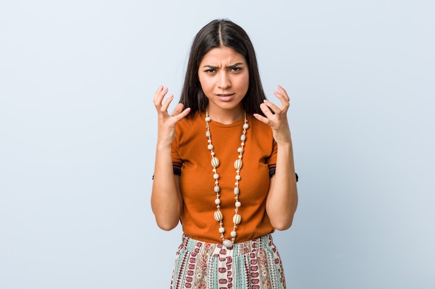 Jonge Arabische vrouw boos schreeuwen met gespannen handen.